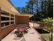 Back patio with dining area, grill, and wooded views, with a partial view of the house at 106 N Lakeside Dr, Smithfield, NC 27577