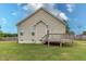 Home back exterior featuring a spacious wooden deck, green lawn, and light tan siding at 1071 Turlington Rd, Dunn, NC 28334