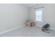 Bright bedroom with neutral carpet, one window and a small bookshelf and chair at 1071 Turlington Rd, Dunn, NC 28334