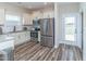 Well-lit kitchen showcasing stainless steel appliances, white cabinets and a view to the backyard at 1071 Turlington Rd, Dunn, NC 28334