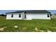 A lovely view of the back exterior featuring white siding and a well-maintained lawn at 110 Coharie Dr, Lillington, NC 27546