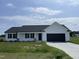 Charming single-story home featuring a black garage door and a well-maintained front lawn at 110 Coharie Dr, Lillington, NC 27546