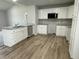 Well-lit kitchen with granite countertops, stainless steel microwave, and stylish wood-look flooring at 110 Coharie Dr, Lillington, NC 27546