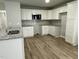 Modern kitchen featuring white cabinets, granite countertops, stainless steel appliances, and laminate flooring at 110 Coharie Dr, Lillington, NC 27546