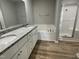 Modern bathroom with double sinks, granite countertops, a soaking tub, and a glass-enclosed shower at 110 Coharie Dr, Lillington, NC 27546