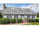 Charming two-story home with gray siding, dormer windows, brick chimney, and a well-manicured front yard at 110 W Quail Ridge Rd, Oxford, NC 27565