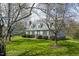 A charming two-story home with a well-manicured lawn framed by mature trees, creating a picturesque setting at 110 W Quail Ridge Rd, Oxford, NC 27565