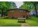 Expansive backyard featuring a brick home, well-manicured lawn, and mature trees at 112 Noble St, Chapel Hill, NC 27516