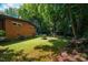 Large backyard with a brick home, lush lawn, and mature trees providing ample shade at 112 Noble St, Chapel Hill, NC 27516