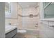 Bathroom features a combined bathtub and shower, white tiles, and elegant fixtures at 112 Noble St, Chapel Hill, NC 27516