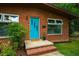 Close-up of front entrance with a vibrant blue door, red brick steps, and neat landscaping at 112 Noble St, Chapel Hill, NC 27516