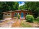 Charming single-story brick home with a vibrant blue front door and mature landscaping at 112 Noble St, Chapel Hill, NC 27516