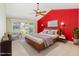 Airy bedroom with large windows, light carpet, modern furniture and red accent wall at 113 Paladin Place, Cary, NC 27513