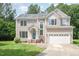 Charming two-story home with manicured lawn, attached garage, and a welcoming teal front door at 113 Paladin Place, Cary, NC 27513