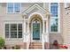 Close up of the covered front entrance with teal door, arched window, and brick stairs at 113 Paladin Place, Cary, NC 27513