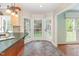 Bright kitchen area with tile floors, green countertops, a bay window, and access to the backyard at 113 Paladin Place, Cary, NC 27513