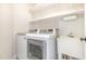 Laundry room with sink, machines, and open shelving for easy organization at 113 Paladin Place, Cary, NC 27513