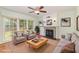 Bright living room features hardwood floors, fireplace, ceiling fan and picture windows with backyard views at 113 Paladin Place, Cary, NC 27513