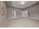 Spacious bedroom featuring tray ceilings, neutral walls, plush carpet, and an elegant chandelier at 1144 Survada Ln, Morrisville, NC 27560