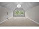 Spacious bonus room with carpet, vaulted ceiling, and large windows for natural light at 1144 Survada Ln, Morrisville, NC 27560