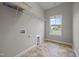 Well-lit laundry room featuring tile floors, shelving and a window for natural light at 1144 Survada Ln, Morrisville, NC 27560