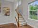 Carpeted stairs with wooden railing ascends past a window with tree view at 1144 Survada Ln, Morrisville, NC 27560