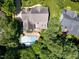 Overhead view of a home showcasing a backyard with a swimming pool, lush landscaping, and an outdoor patio at 121 Flint Point Ln, Holly Springs, NC 27540
