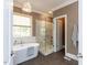 Elegant bathroom with a soaking tub and glass shower, illuminated by a modern pendant light fixture at 121 Flint Point Ln, Holly Springs, NC 27540