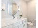Clean bathroom featuring single sink, large mirrors, modern fixtures, and a linen cabinet at 121 Flint Point Ln, Holly Springs, NC 27540