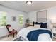 Bright bedroom featuring stylish decor, large windows, and a comfortable bed with blue accents at 121 Flint Point Ln, Holly Springs, NC 27540