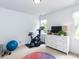 Exercise room featuring stationary bike, free weights, large windows, and a white dresser at 121 Flint Point Ln, Holly Springs, NC 27540