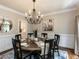 Charming dining room with dark wood table, chandelier, and wainscoting, creating a cozy and inviting atmosphere at 121 Flint Point Ln, Holly Springs, NC 27540