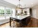 Bright kitchen featuring a large island, modern lighting, white cabinets, and hardwood floors, ideal for everyday living at 121 Flint Point Ln, Holly Springs, NC 27540