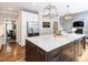 Open-concept kitchen with an island, white cabinets, stainless steel appliances, and hardwood floors, great for entertaining at 121 Flint Point Ln, Holly Springs, NC 27540