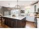 Spacious kitchen with a large island, white cabinets, stainless steel appliances, and hardwood floors, perfect for cooking at 121 Flint Point Ln, Holly Springs, NC 27540