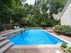 Sparkling pool area with brick patio, waterfall feature, and seating for outdoor relaxation at 121 Flint Point Ln, Holly Springs, NC 27540