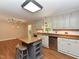 Well-lit kitchen features an island, granite countertops, stainless steel appliances, and wood flooring at 1215 Brookgreen Dr, Cary, NC 27511