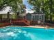 Sparkling backyard pool is nestled amidst lush trees and a wooden deck at 1215 Brookgreen Dr, Cary, NC 27511