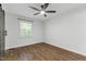 An airy bedroom with a ceiling fan, wood-look flooring and a modern barn door closet at 129 Assembly Ct, Cary, NC 27511