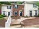 Charming townhome exteriors featuring brick and white siding with manicured landscaping at 129 Assembly Ct, Cary, NC 27511