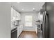 Well-lit kitchen features stainless steel appliances, granite countertops, and white cabinets at 129 Assembly Ct, Cary, NC 27511
