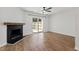 Living room featuring fireplace, hardwood floors, ceiling fan, and sliding glass door at 129 Assembly Ct, Cary, NC 27511