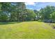 Expansive backyard with lush green grass, mature trees, and plenty of room for outdoor activities at 1413 Roy Averette Dr, Raleigh, NC 27603