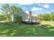 A cozy backyard deck featuring black railings and a brick chimney, perfect for outdoor relaxation at 1413 Roy Averette Dr, Raleigh, NC 27603