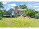 Rear view of the house featuring a deck and spacious backyard with plenty of green space at 1413 Roy Averette Dr, Raleigh, NC 27603