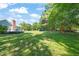 Expansive backyard perfect for recreation, featuring mature trees and a play area at 1413 Roy Averette Dr, Raleigh, NC 27603
