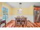Bright dining area with hardwood floors, a globe pendant light, and view into the kitchen at 1413 Roy Averette Dr, Raleigh, NC 27603