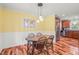 Cozy dining room featuring hardwood floors, globe pendant lights, and a view into the kitchen at 1413 Roy Averette Dr, Raleigh, NC 27603