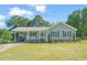 Charming single story home with a covered front porch, blue shutters, and a well-maintained front lawn at 1413 Roy Averette Dr, Raleigh, NC 27603