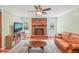 Cozy living room featuring a brick fireplace, hardwood floors, and natural light from the windows at 1413 Roy Averette Dr, Raleigh, NC 27603